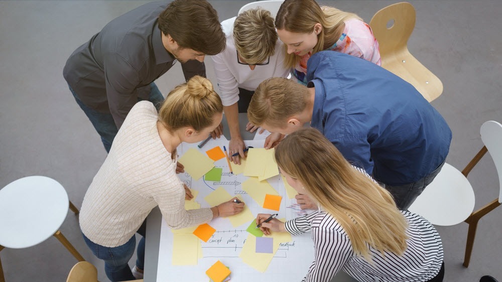 Weiterbildungen im Vertrieb als Teamevent_Mitarbeitergruppe löst gemeinsam eine Aufgabe