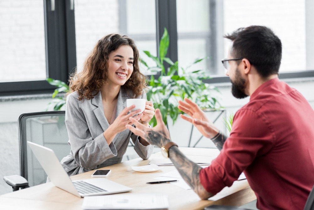 Account Manager sitzt gemeinsam mit einer Kundin am Tisch und führt ein Beratungsgespräch