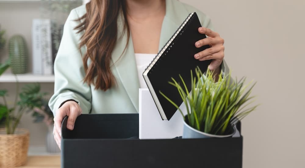 richtig kündigen als Arbeitnehmer junge Frau verlässt nach Übergabe ihren Arbeitsplatz