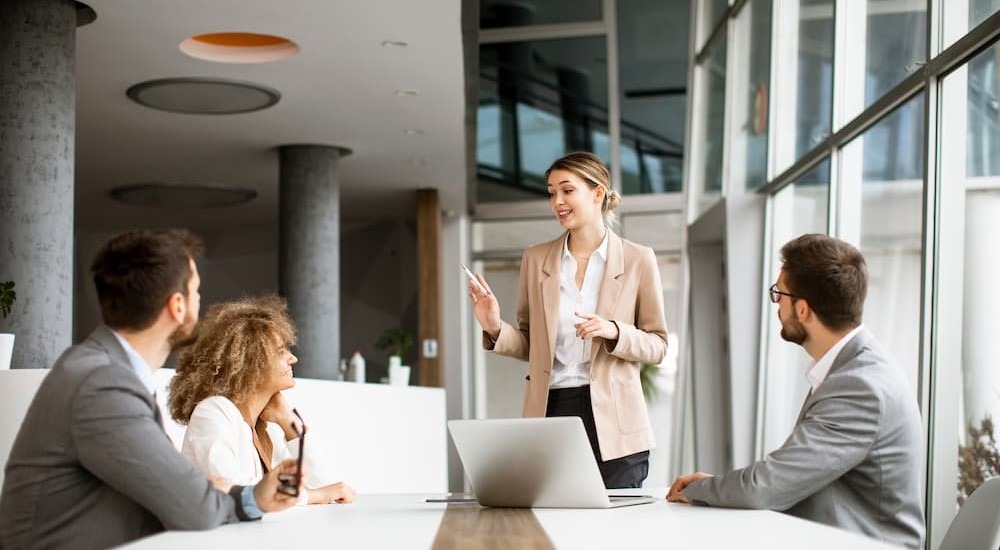 Key Account Managerin bespricht Projekt mit Kunden in einem modernen Büro